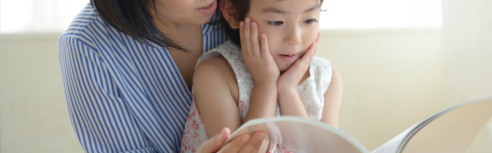 母親が子どもに絵本を読み聞かせている